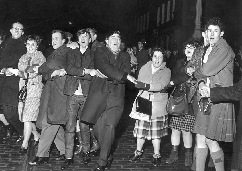 People singing Auld Lang's Syne during New Year at the Tron, Edinburgh 1964.