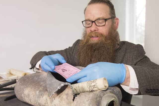 Conservator Nic Boyes ACR opens the capsule. Picture: Neil Hanna